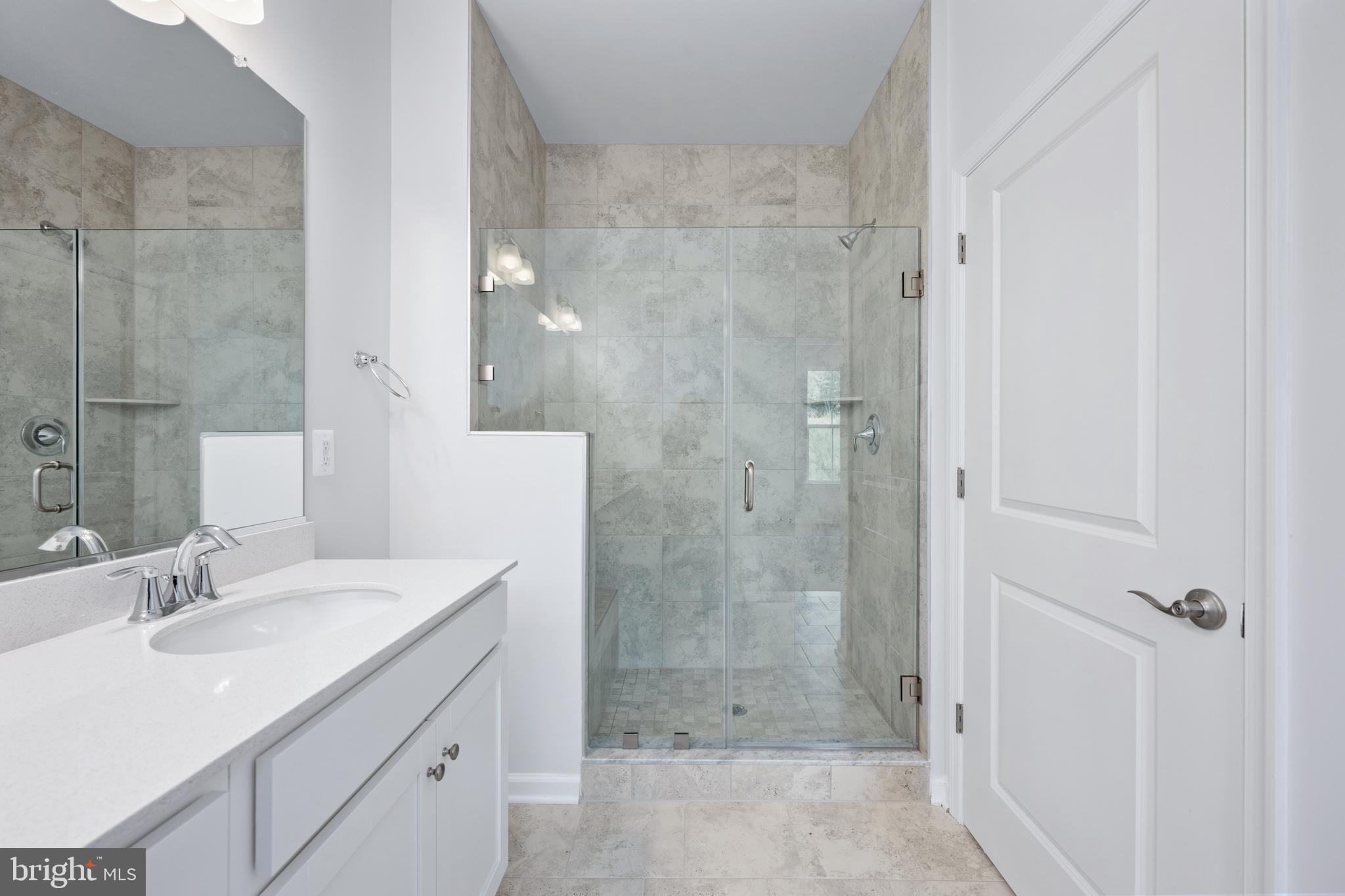 29 Hyssop Way, Unit 103 Stafford, VA 22554 - Photo 39 of 39 a bathroom with a shower sink and mirror