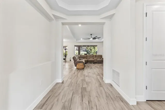 a living room with stainless steel appliances kitchen island furniture and a wooden floor