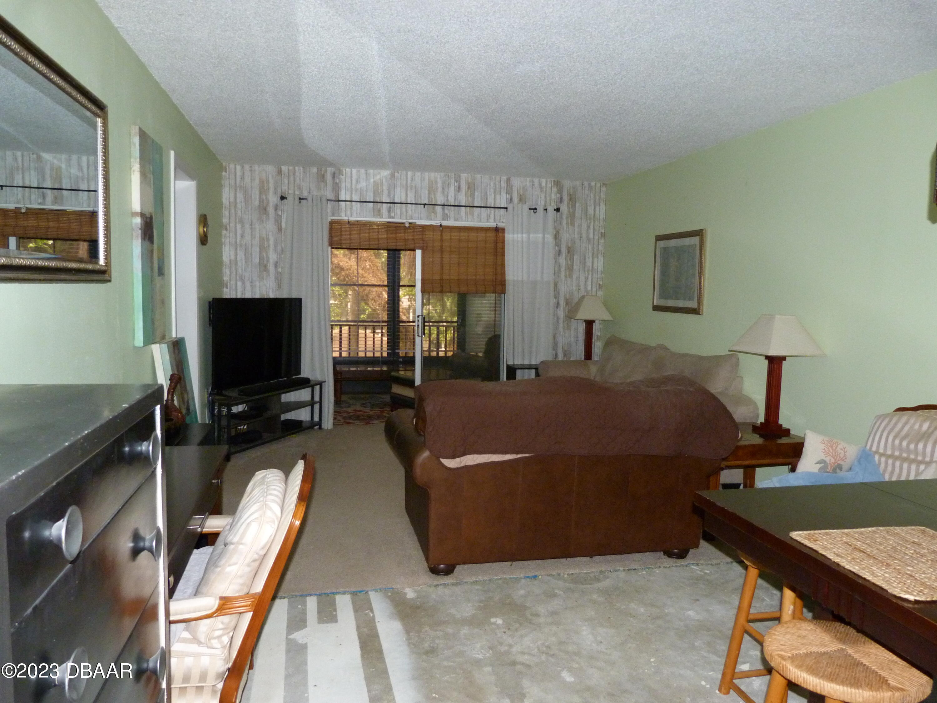 640 North Nova Road, Unit 303 Ormond Beach, FL 32174 - Photo 15 of 31 a living room with a bed furniture and a flat screen tv
