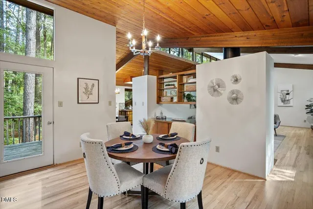 a view of a dining room with furniture a chandelier and wooden floor