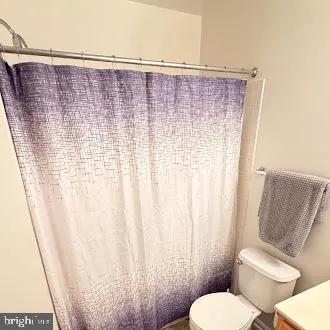 a bathroom with a toilet and a shower curtain
