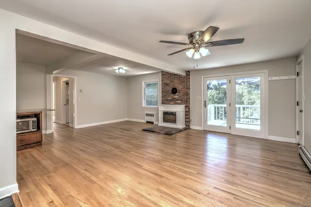 a view of a livingroom with a hardwood floor and a ceiling fan