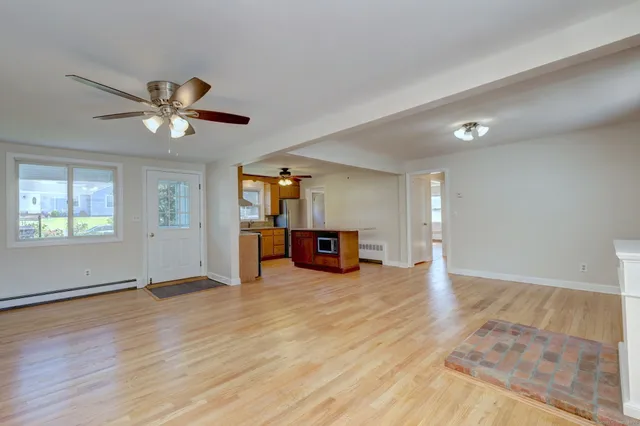 a view of a livingroom with a window and a kitchen