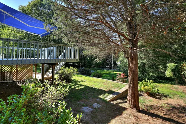 a view of a deck with a table and chairs next to a yard