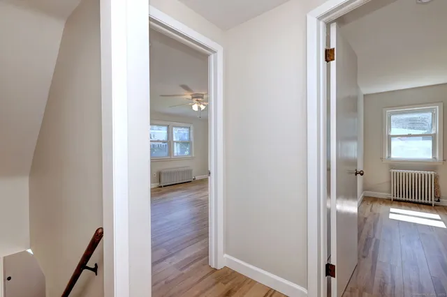 a view of a hallway with wooden floor and stairs
