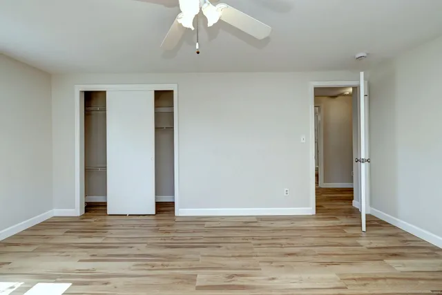 an empty room with wooden floor and closet