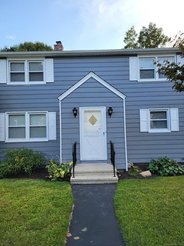 a front view of a house with a garden