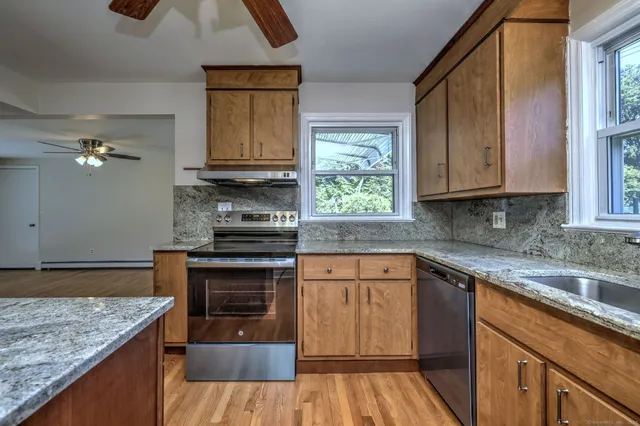 a kitchen with granite countertop a sink and a stove