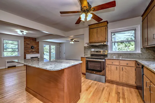 a kitchen with stainless steel appliances granite countertop a stove a sink and a refrigerator