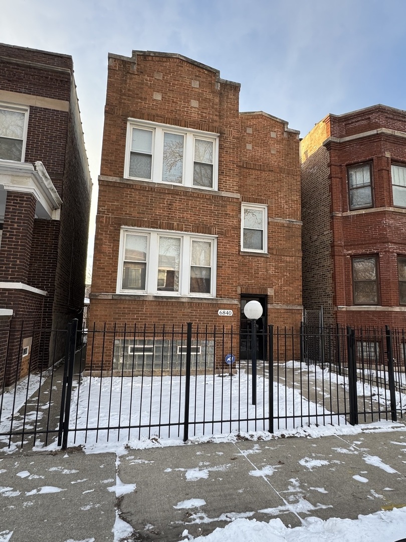 a front view of a house with a iron gate