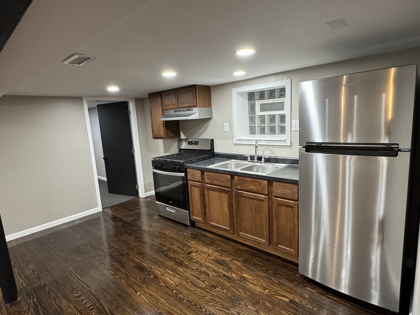 6840 South Champlain Avenue, Unit G Chicago, IL 60637 - Photo 5 of 11 a kitchen with stainless steel appliances granite countertop a refrigerator a sink a stove a microwave and island with wooden floor
