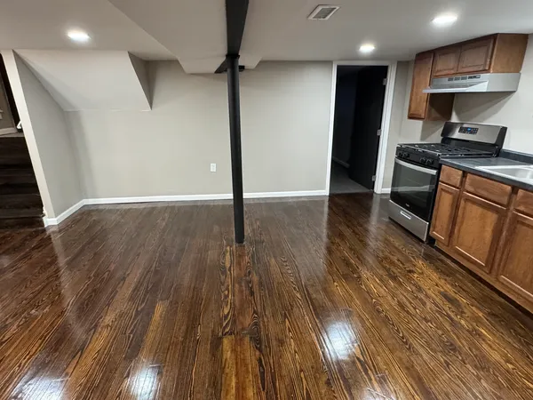 a kitchen with stainless steel appliances granite countertop a refrigerator a stove and a wooden floors