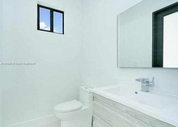 3024 Southwest 16th Terrace, Unit 3024 Miami, FL 33145 - Photo 9 of 16 a bathroom with a granite countertop toilet sink and mirror