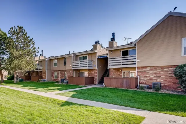 an empty room with windows fireplace and a ceiling fan