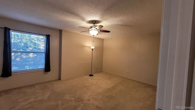 en empty room with windows and fan