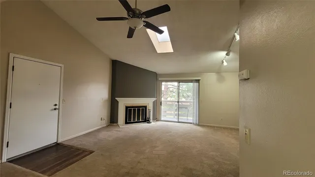 wooden floor in an empty room with a fireplace and a window