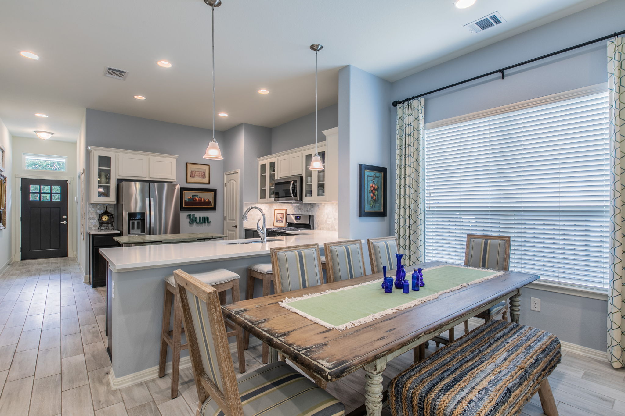 231 Simon Kyle, TX 78640 - Photo 11 of 29 Open-concept dining area featuring wood-finish tile flooring and a large window with blinds