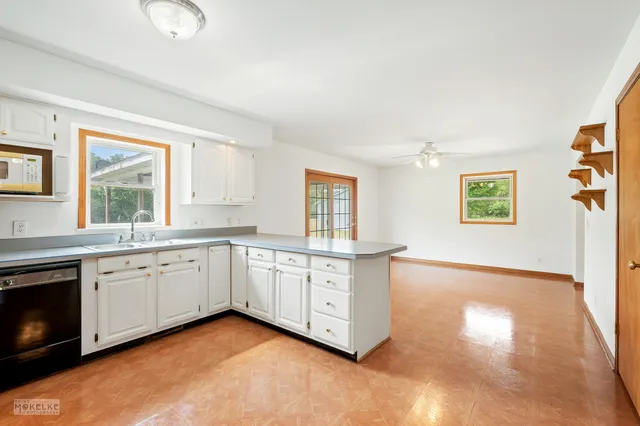 a large kitchen with granite countertop a stove a sink and a microwave