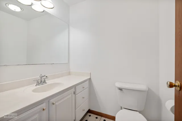 a bathroom with a sink vanity mirror and toilet
