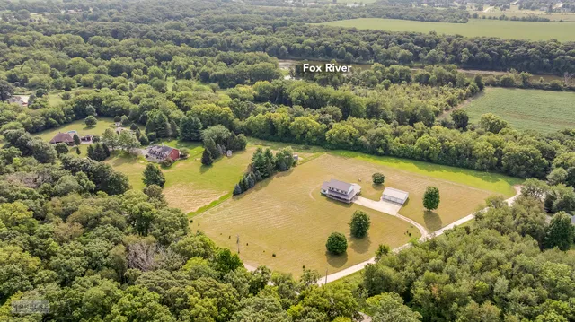 an aerial view of residential houses with outdoor space and lake view
