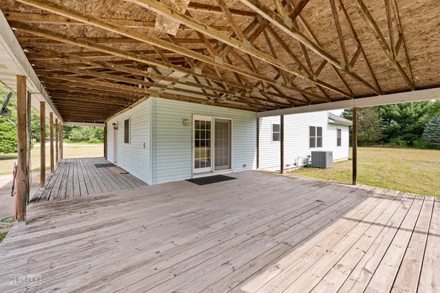a view of backyard with wooden deck and floor to ceiling window