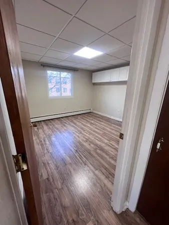 a view of empty room with cabinet and wooden floor