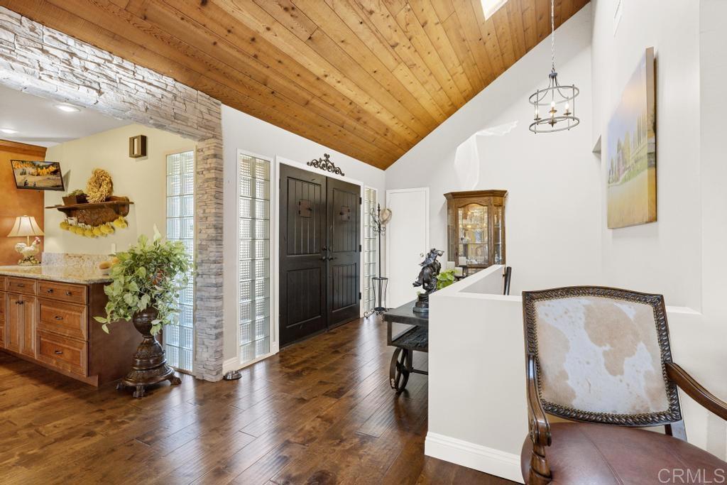 1131 Rainbow Valley Boulevard Fallbrook, CA 92028 - Photo 12 of 73 a hallway with table and flowerpot with wooden floor