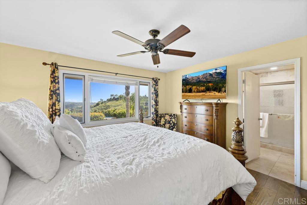 1131 Rainbow Valley Boulevard Fallbrook, CA 92028 - Photo 14 of 73 a bedroom with a bed and a chandelier