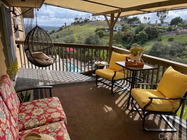 1131 Rainbow Valley Boulevard Fallbrook, CA 92028 - Photo 30 of 73 a balcony with wooden floor table and chairs