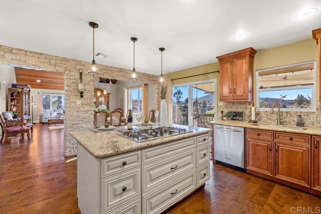 1131 Rainbow Valley Boulevard Fallbrook, CA 92028 - Photo 4 of 73 a kitchen with stainless steel appliances granite countertop a stove a oven and a wooden floors