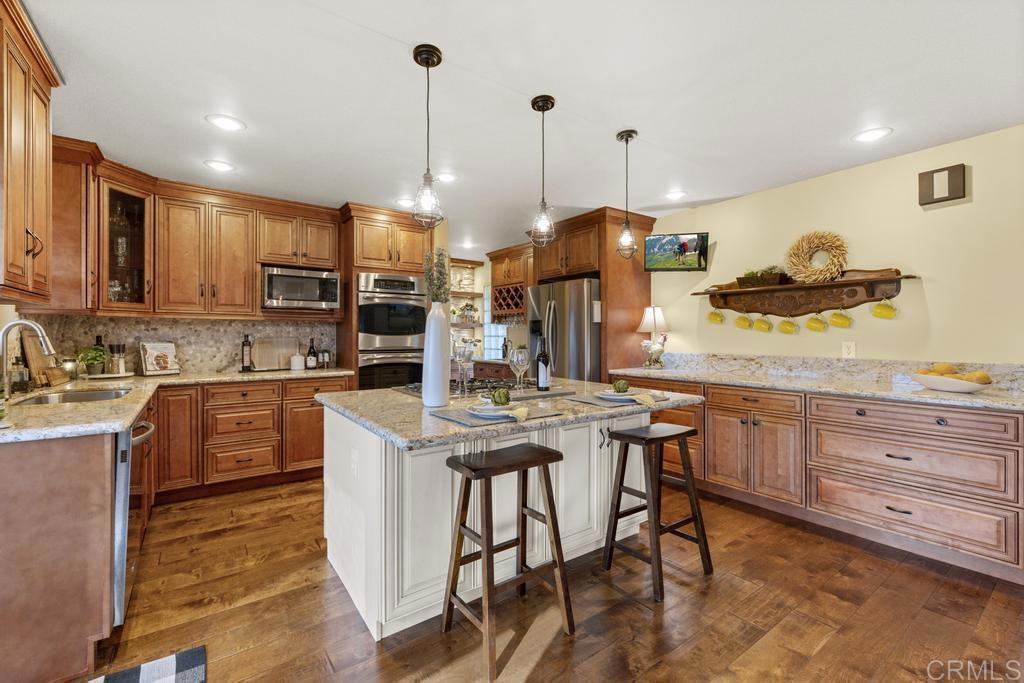 1131 Rainbow Valley Boulevard Fallbrook, CA 92028 - Photo 6 of 73 a kitchen with stainless steel appliances kitchen island granite countertop a stove a sink and a refrigerator