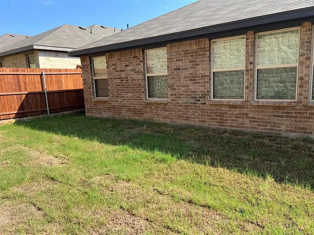 a view of a backyard that has brick walls and a large window