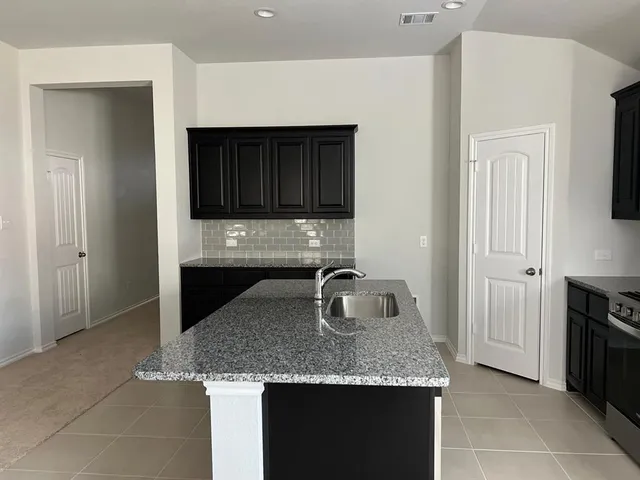 a kitchen with granite countertop a sink and a stove top oven with granite countertops