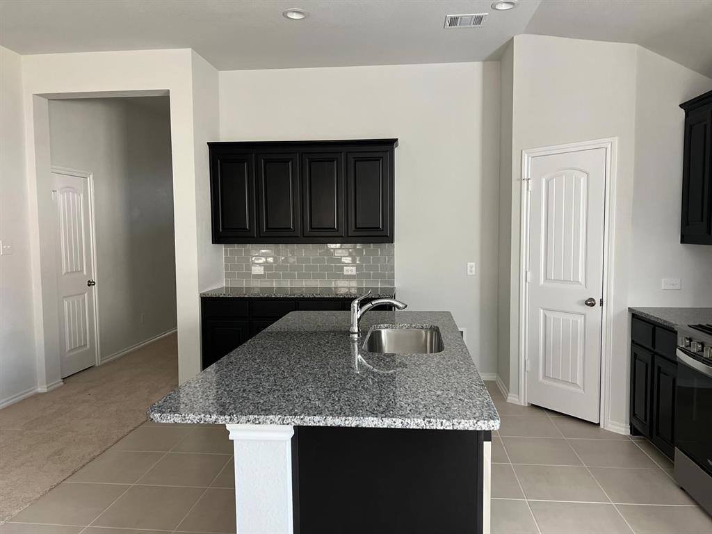 1809 Osage Trail Mesquite, TX 75149 - Photo 4 of 18 a kitchen with granite countertop a sink and a stove top oven with granite countertops