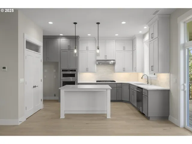 a kitchen with kitchen island white cabinets and stainless steel appliances