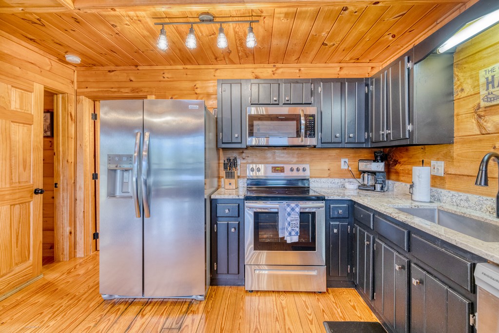 31 The Kings Court Cherry Log, GA 30522 - Photo 8 of 50 a kitchen with kitchen island granite countertop wooden cabinets a sink and dishwasher