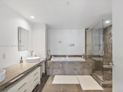 a bathroom with a granite countertop sink a toilet a mirror and shower