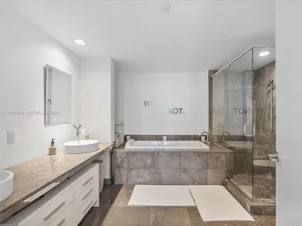 a bathroom with a granite countertop sink a toilet a mirror and shower