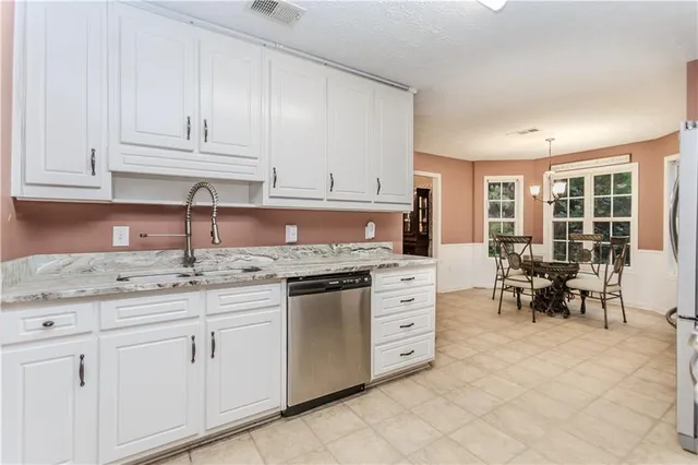 a kitchen with granite countertop white cabinets and white appliances