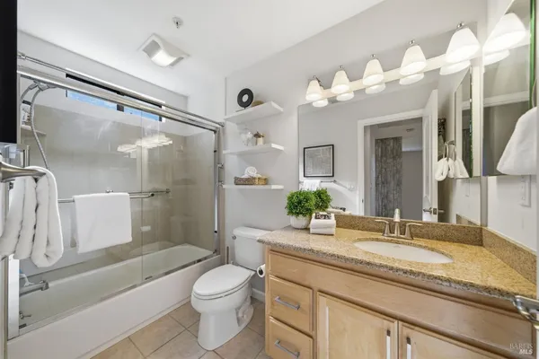 a bathroom with a granite countertop sink mirror toilet and shower