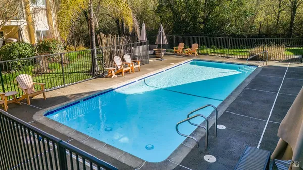 a view of a swimming pool with a patio and a lake view