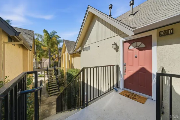 a view of a house with a small yard and wooden floor and fence