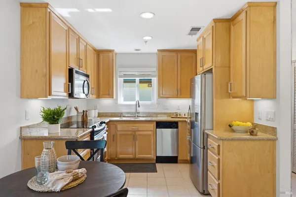 a kitchen with stainless steel appliances granite countertop a sink a stove and a refrigerator