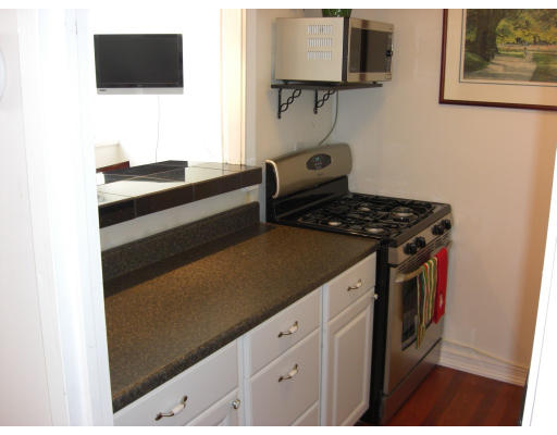 65 East India Row, Unit 16E Boston, MA 02110 - Photo 3 of 11 a kitchen with a stove and a flat screen tv