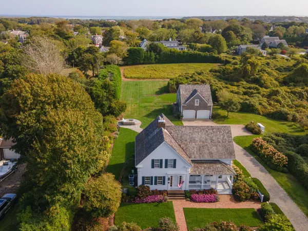 an aerial view of residential houses with outdoor space and ocean view
