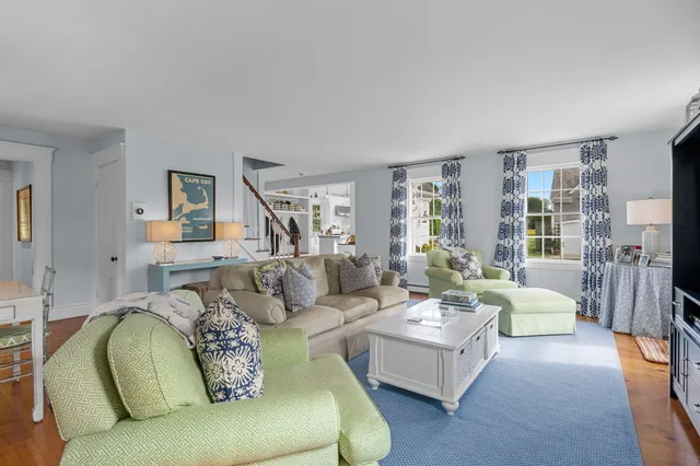 a kitchen with stainless steel appliances granite countertop a refrigerator a sink dishwasher a stove and white cabinets with wooden floor