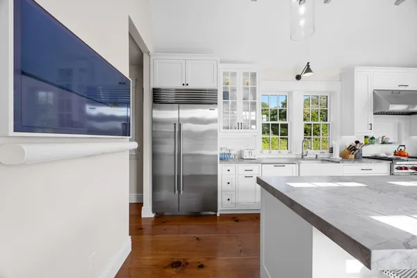 a kitchen with granite countertop a white stove top oven sink and wooden floor