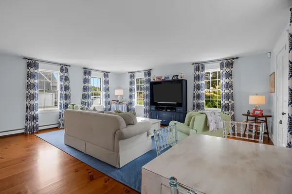 a dining room with furniture a chandelier and wooden floor