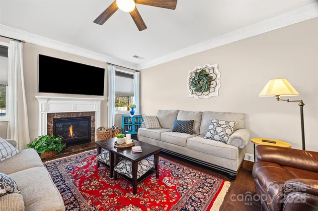 a living room with furniture a flat screen tv and a fireplace