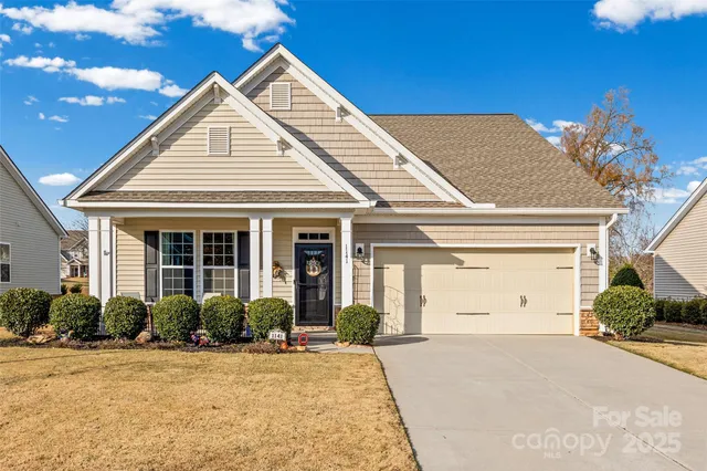 a view of white house with a yard and potted plants